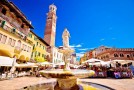 Piazza-delle-erbe-in-Verona-street-and-market-view-with-Lamberti-tower-tourist-destination-in-Veneto-region-of-Italy-min